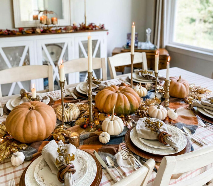 Pumpkins and candles in the center of dining table