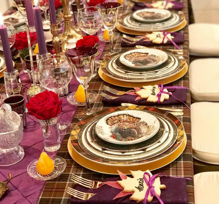 Plates and glasses on dining table in purple color