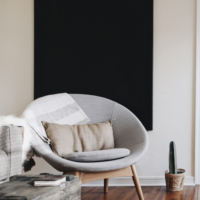Round grey chair with brown pillow on it 