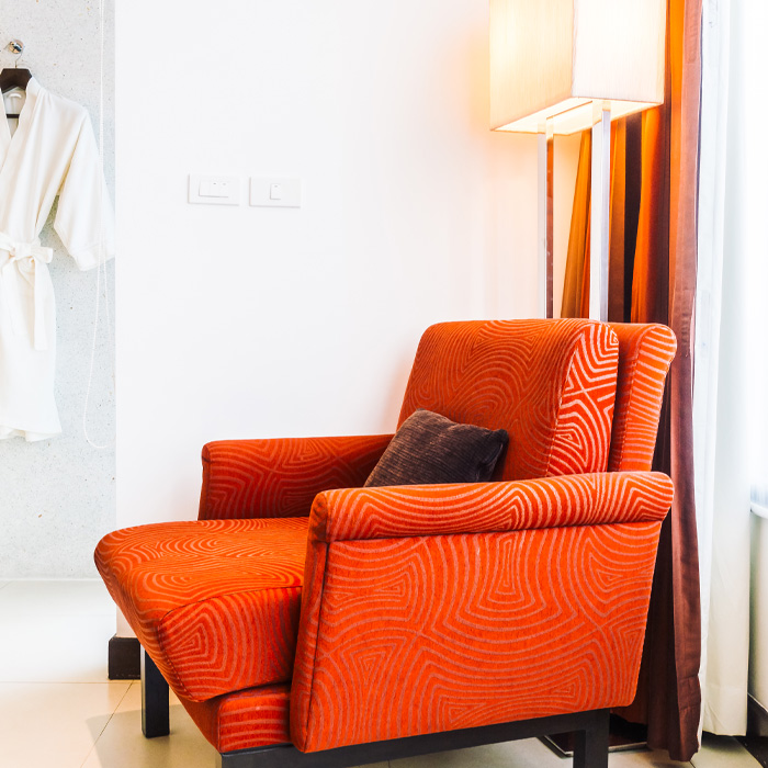 Orange chair with brown pillow on it 