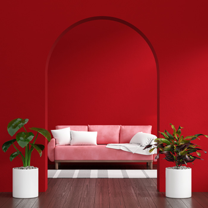 Pink sofa in red living room showcasing warm colors decor with white pillows and green plants in modern interior design. Pink sofa in red living room showcasing warm colors decor with white pillows and green plants in modern interior design.