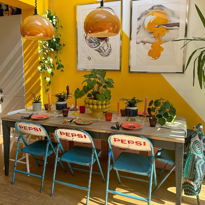 Yellow dining room with blue chairs and grey table 