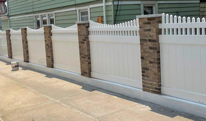 A wave-shaped PVC white picket fence
