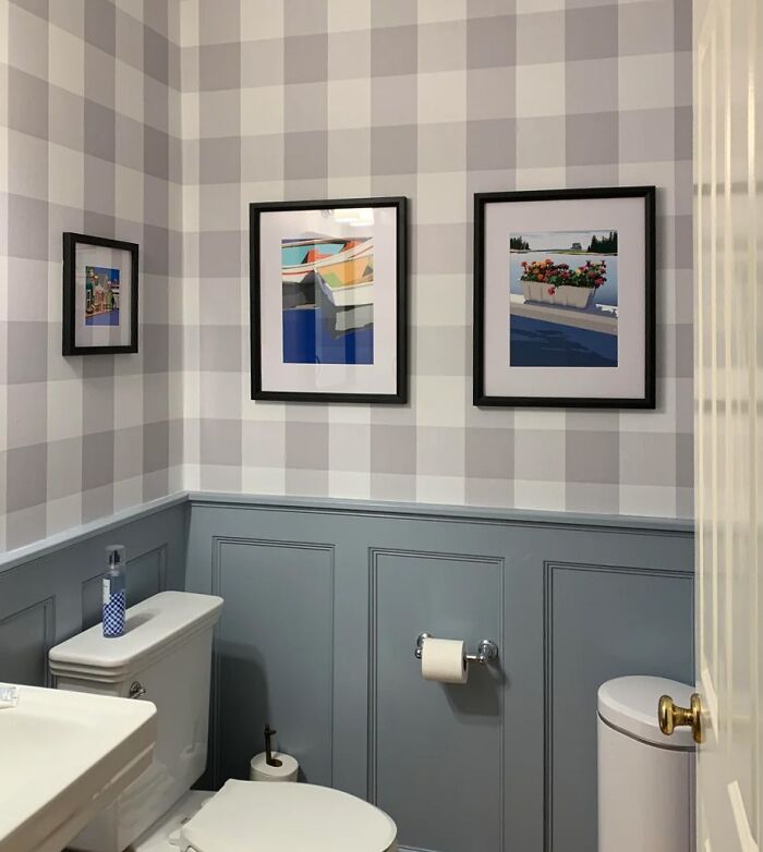 Bathroom with gray wainscoting, wallpaper and wall art