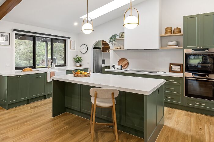 Kitchen with dark olive green cabinets and white countertops
