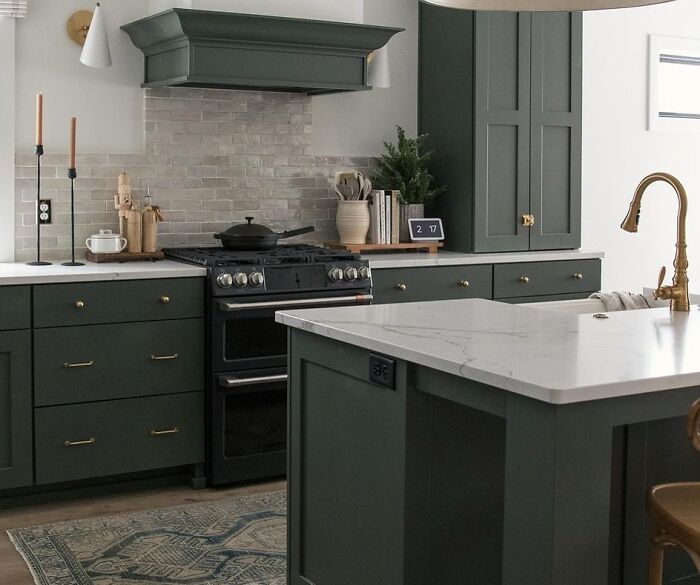 Dark green kitchen with cabinets and white countertops