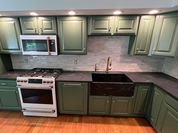 Green kitchen cabinets with brass fixtures
