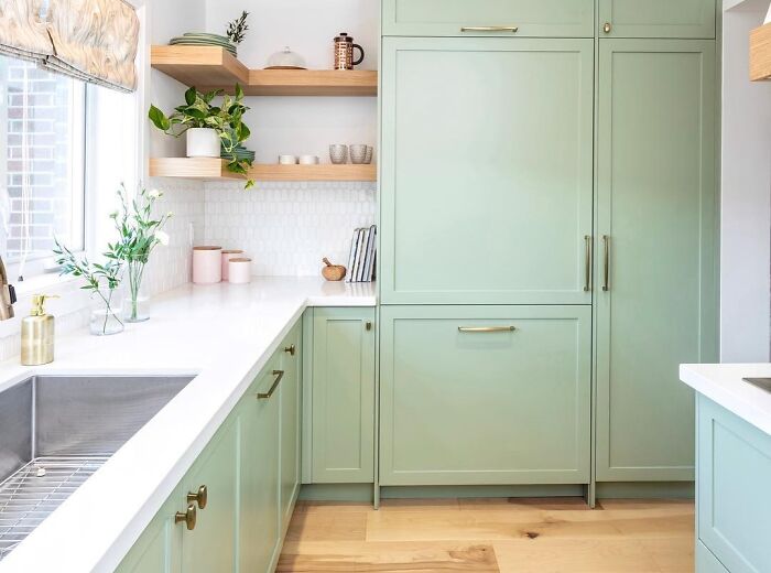 Light green kitchen cabinets with white countertops