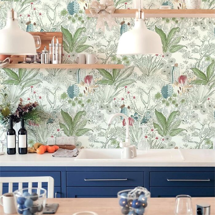 Kitchen with botanical and tropical pattern wallpaper and blue cupboards