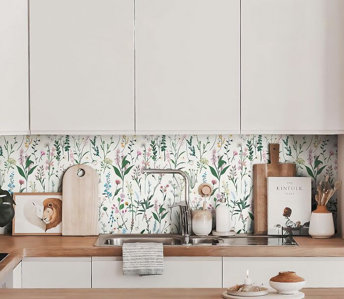 Kitchen with colorful floral wallpaper and creamy color cupboards