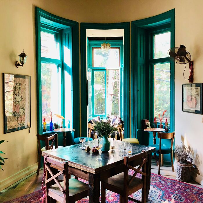 Dining room with large windows, wooden table, and chairs showcasing inspiring dining room ideas for gatherings and parties.