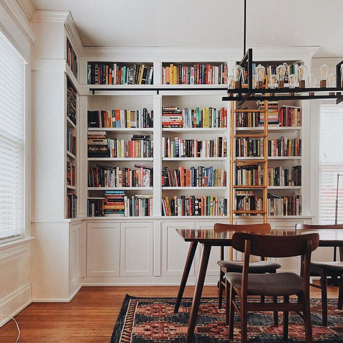 Room with white bookshelve and rug with table and chairs