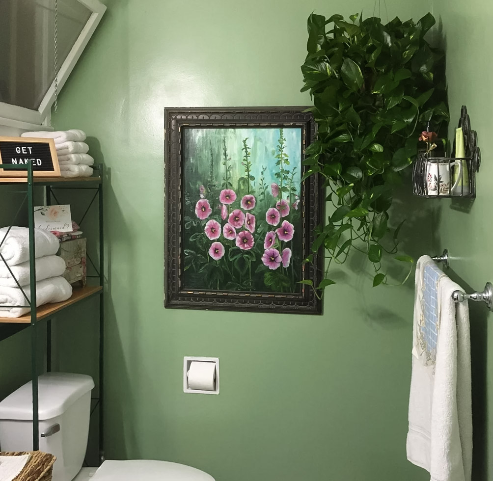 Green bathroom with painting and plant