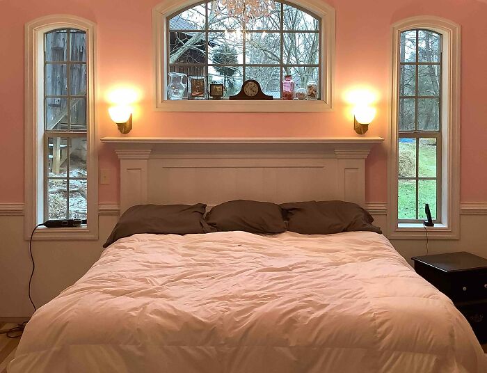 Pastel pink bedroom with wainscoting headboard and symmetric lights