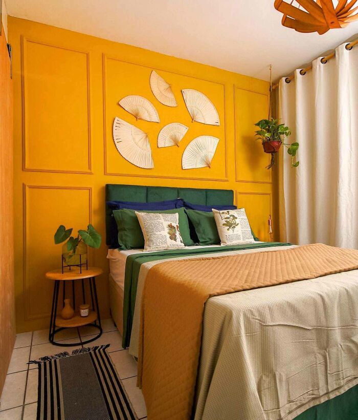 Bedroom with yellow wainscoting and folding fans wall art