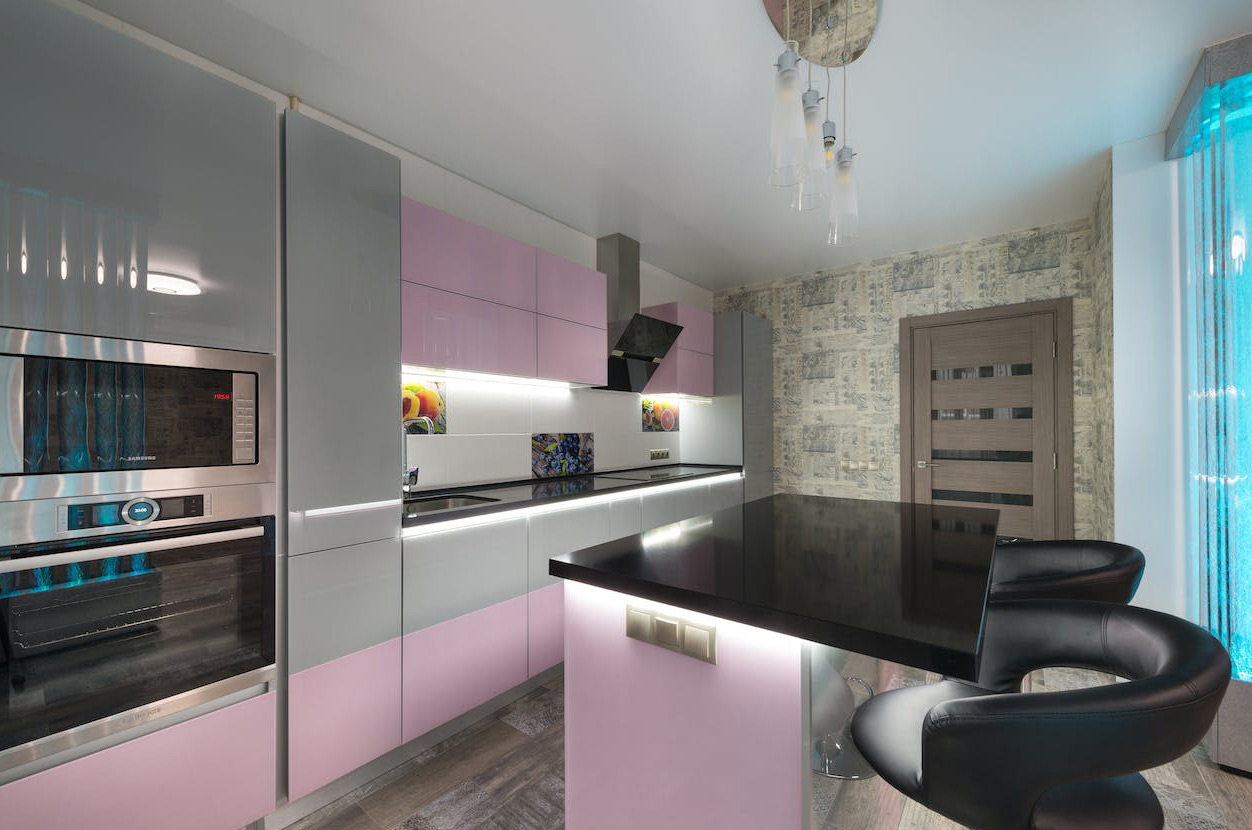 Kitchen with black polished concrete countertops and light pink cabinets
