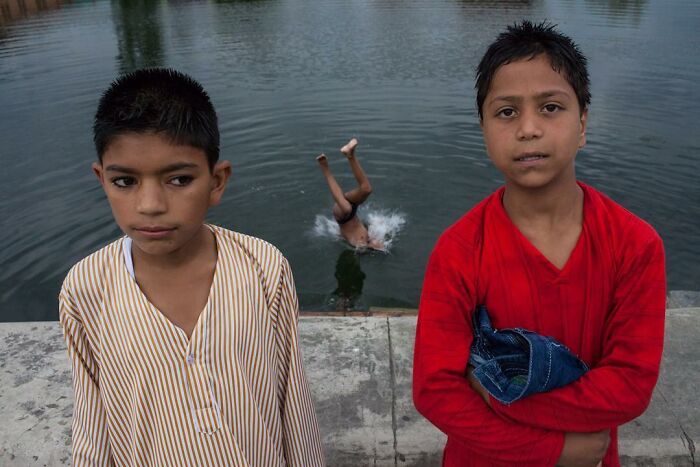 A Photograph Of Boys Next To Water