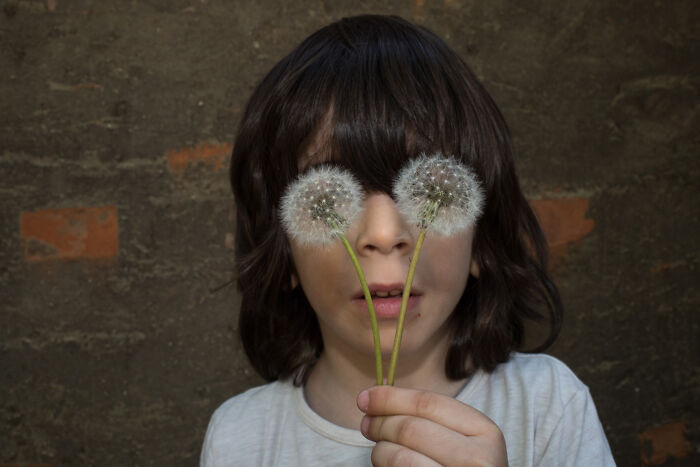 A Photograph Of A Kid With Flowers