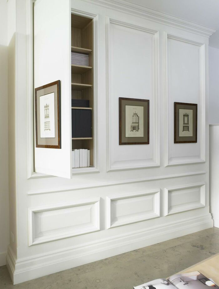 White wainscoting with wall art and hidden storage