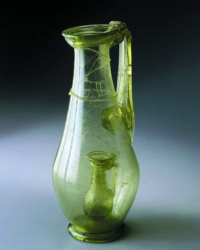 Jarra romana de vidrio con una jarra más pequeña en su interior. Una jarra de broma que demuestra la habilidad del vidriero