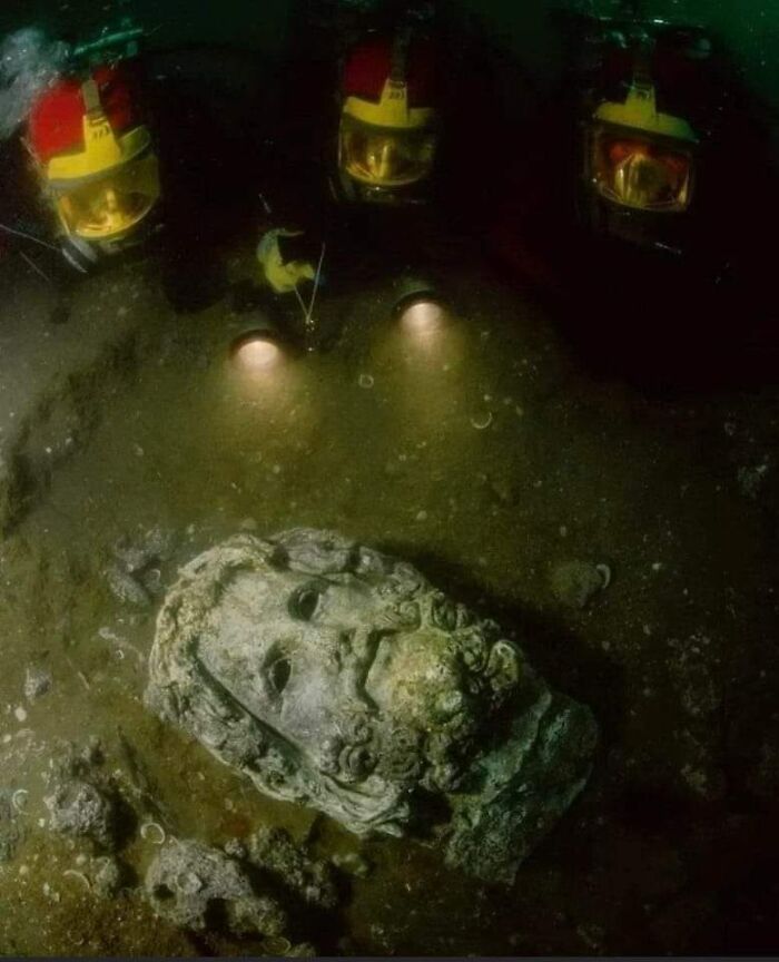 Divers Shining Lights On A Head Of Serapis, Found In The Sunken Egyptian Coastal Town Of Canopus. The Full Statue Was Once Over 4 Metres Tall And Dates To Circa 200 B.c