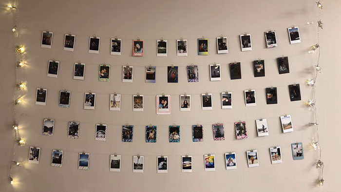 Polaroids hung up on strings on the wall 
