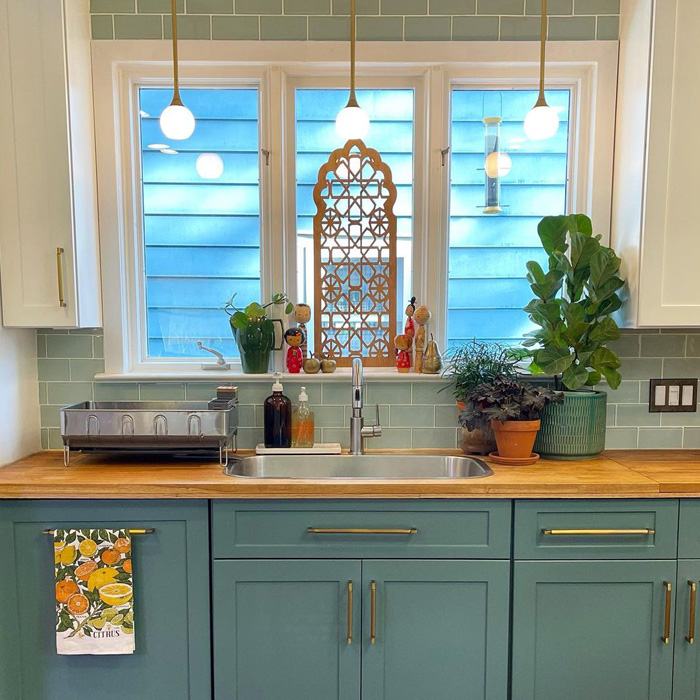 Green kitchen cabinets with butcher block countertop