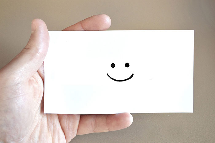 Smile face wriiten on the paper card