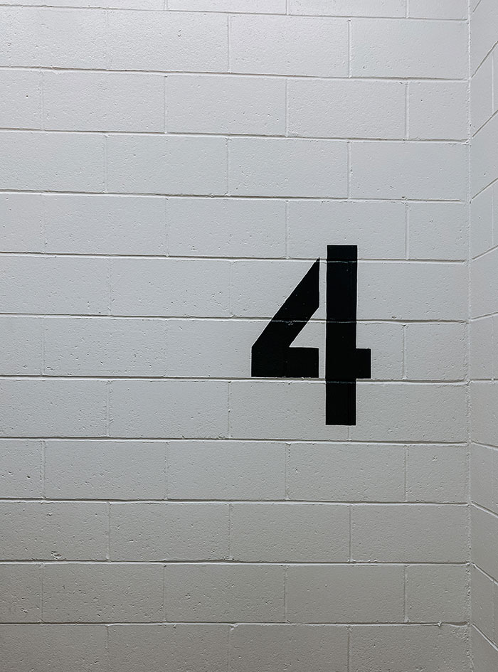 Number 4 written on white brick wall