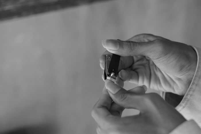 Person cutting his fingernail using nail clipper