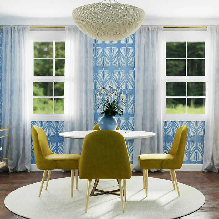 Blue patterned dining room with a white table and yellow chairs, perfect for family gatherings and parties.