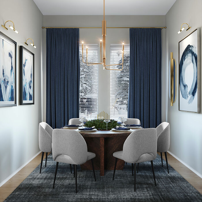 Dining room with modern white chairs, round wooden table, blue curtains, and abstract paintings for family gatherings.