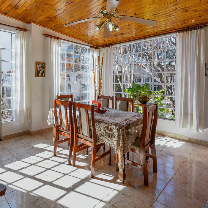 Dining room with wooden table and chairs, natural light, and wooden ceiling showcasing inspiring dining room ideas.