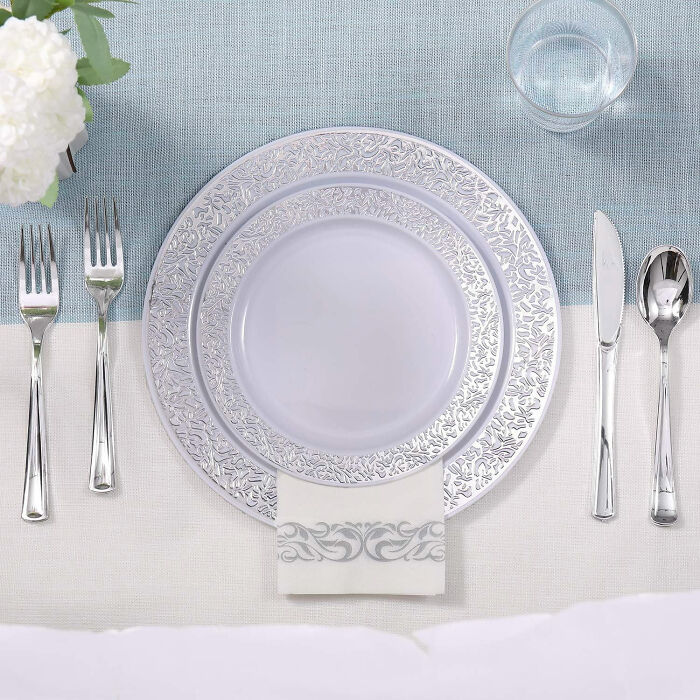 Elegant dining room table setting with decorative plates, silverware, and a glass to enhance family gatherings and parties.