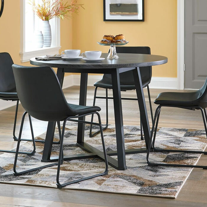 Yellow dining room with black table and chairs styled for inspiring dining room ideas to beautify family gatherings.
