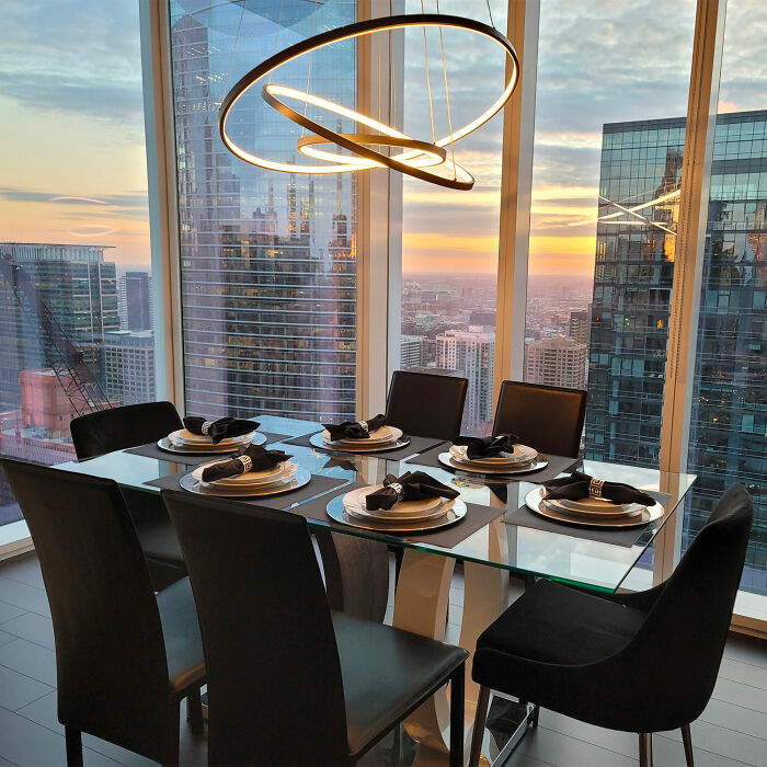 Modern dining room with glass table and black chairs near balcony, perfect for inspiring dining room ideas and family gatherings.