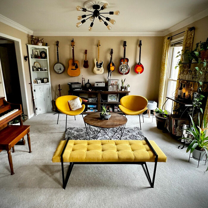 Dining room with wooden table and yellow chairs, decorated with guitars on the wall for family gatherings and parties.