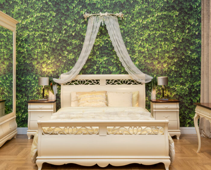 Beige bed near the wall with a green leaves wallpapers
