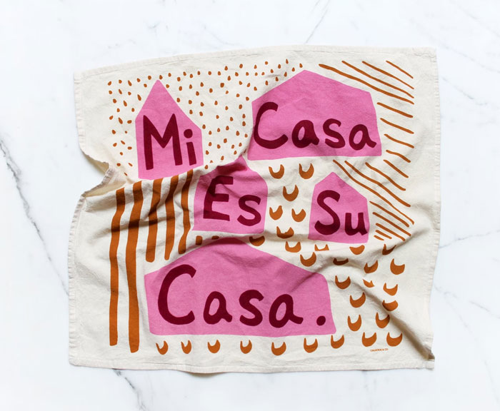 Mi Casa Es Su Casa Printed Tea Towel: Printed tea towel because who wouldn't love to wrap up a wine bottle for a housewarming in a 100% cotton towel that radiates positive messages and cozy vibes?