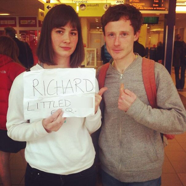 Woman and man holding a greeting sign 
