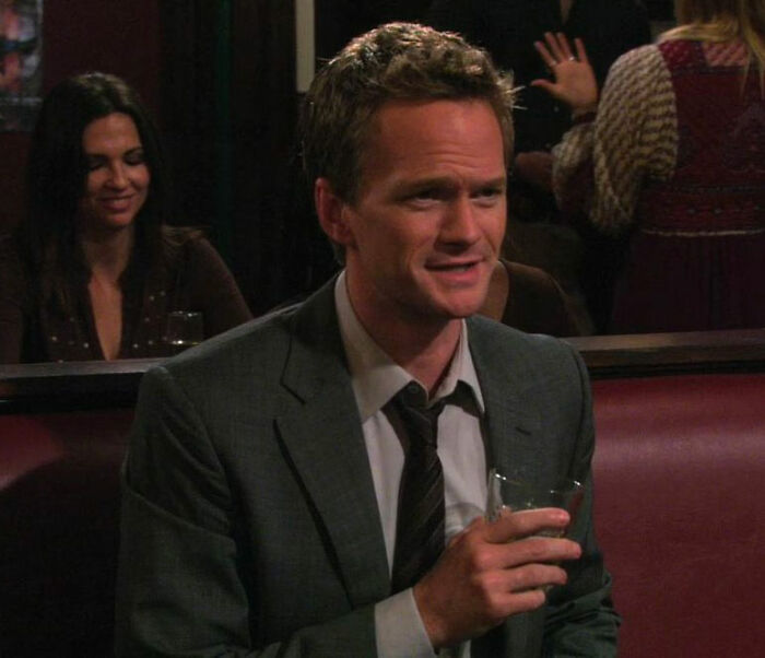 Barney Stinson sitting and drinking from How I Met Your Mother