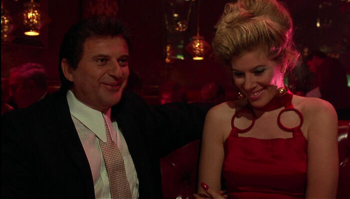 Tommy DeVito sitting and laughing with woman from Goodfellas
