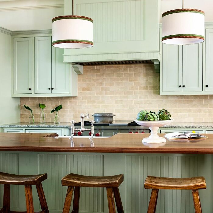 Light green kitchen with green cabinets and wooden countertops