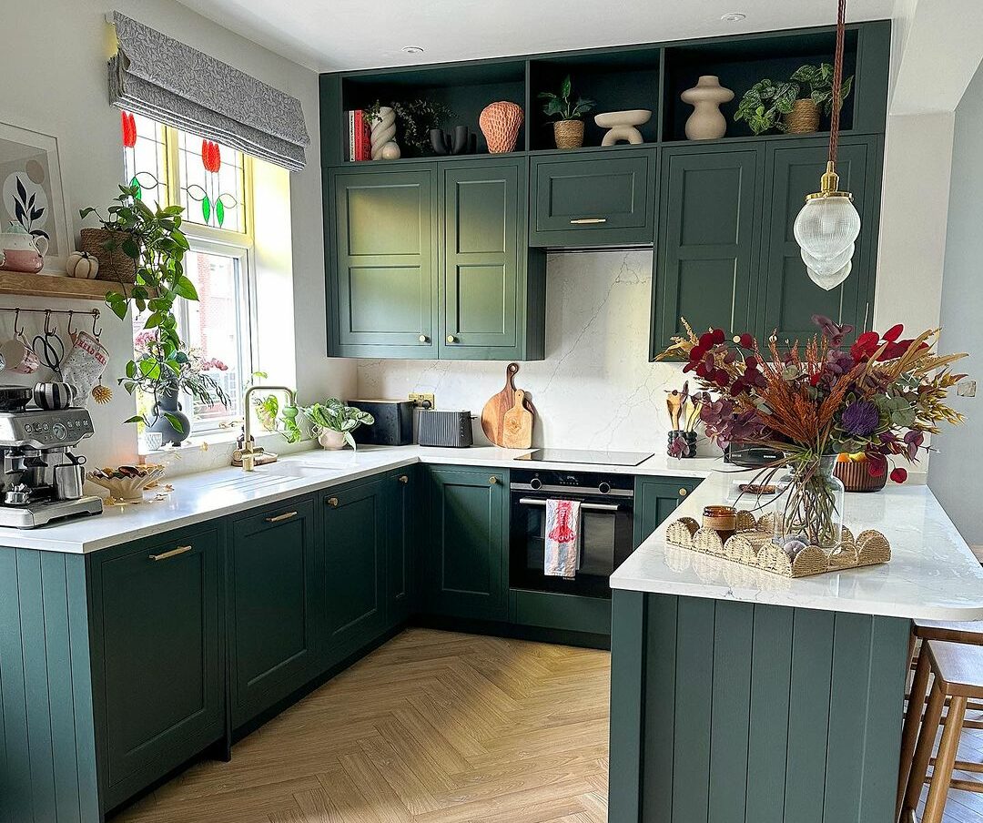 Light green kitchen with green cabinets and white countertops