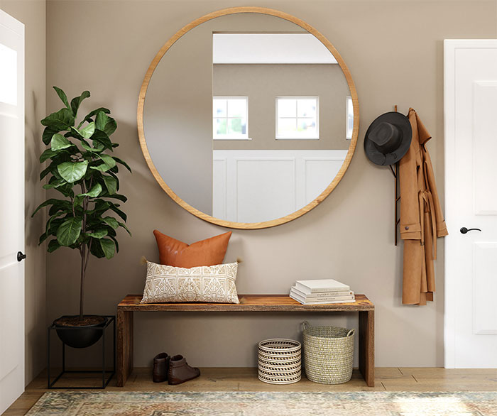 Brown wooden framed mirror on gray wall and plant near