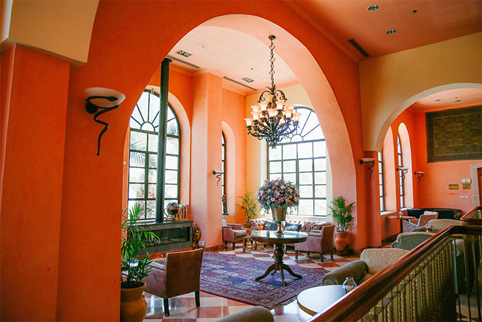 A large bright orange room with lots of furniture and a chandelier
