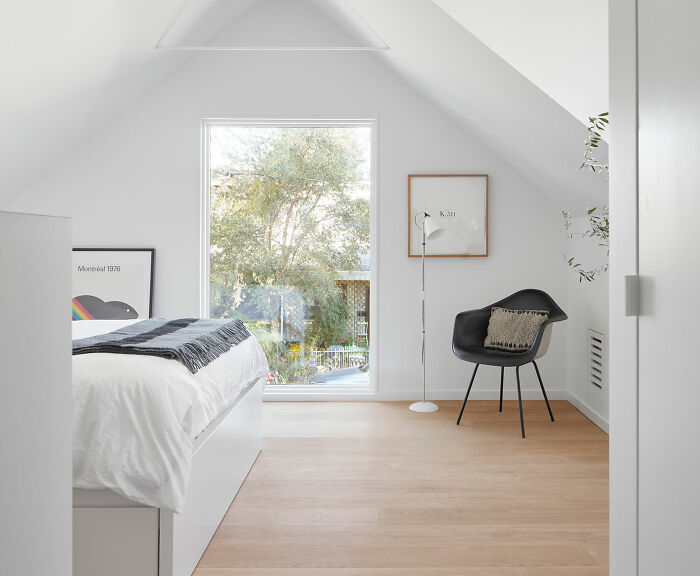 White room with bed and black chair