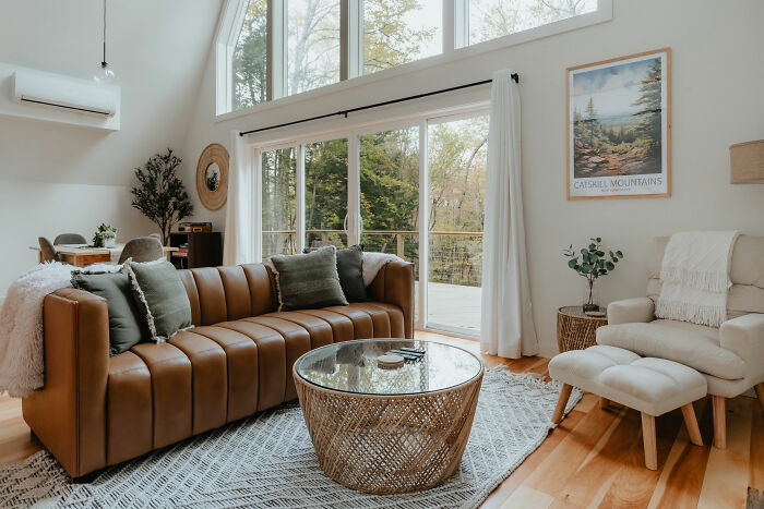 A living room filled with furniture, leather sofa and a large window