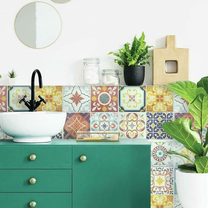 Kitchen with colorful mosaic tile wallpaper and green cupboards with flowers