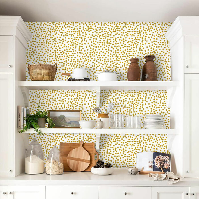 Kitchen with modern yellow polka dots wallpaper and white shelves